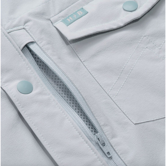 Close-up of mesh ventilation lining and snap pocket on Howler Bros tech shirt