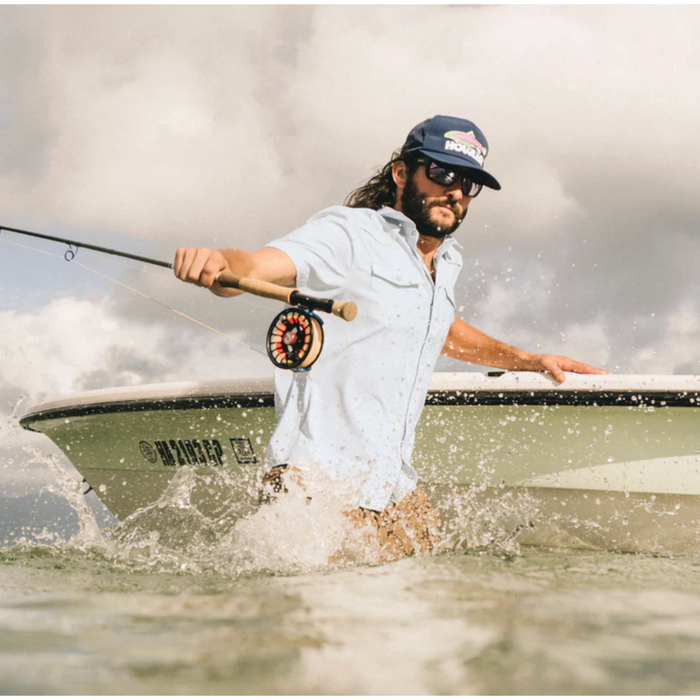 Man wearing Howler Bros light blue UPF 35 fishing shirt while fly fishing